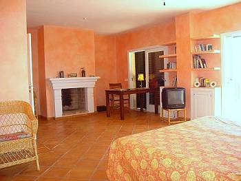 Schlafzimmer mit Doppelbett und Kamin